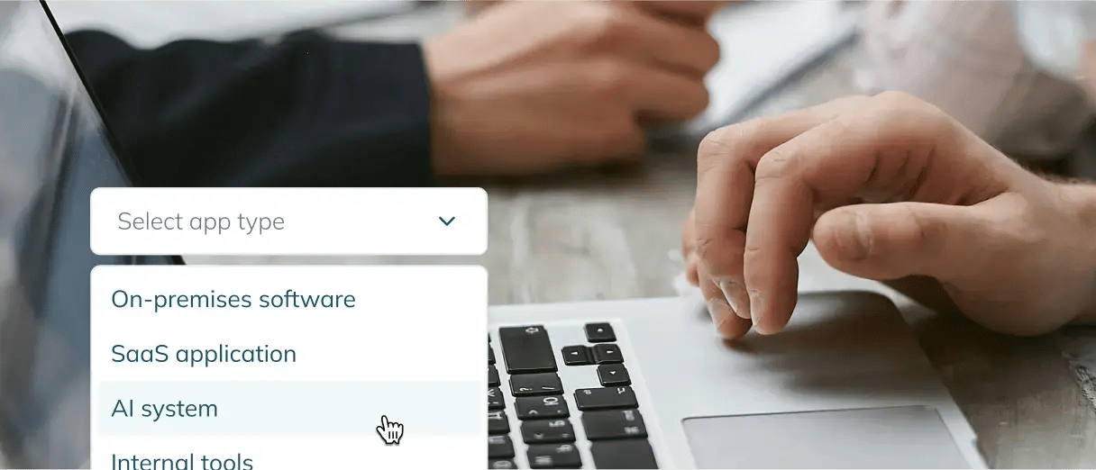 A close-up of a person using a laptop with a 'Select app type' dropdown menu UI snippet in the bottom-left corner.