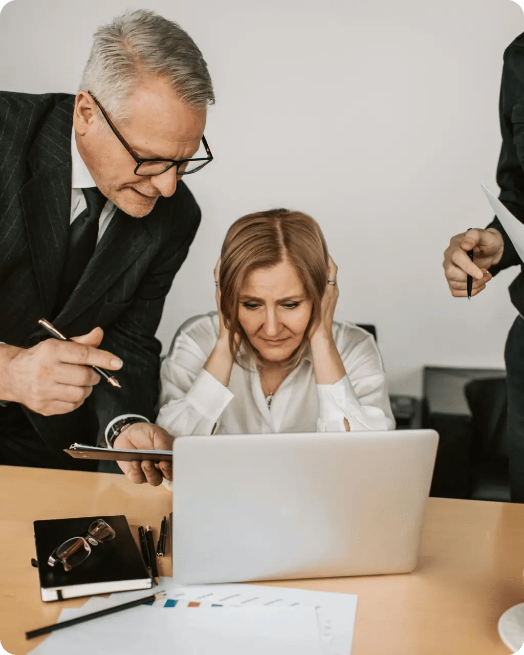 A collaborative team gathered around a computer screen in deep discussion.