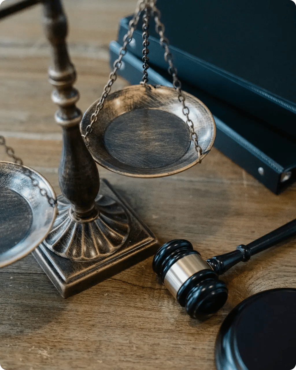A legal professional taking notes in a notebook, featuring a Lady Justice scale emblem in the background.